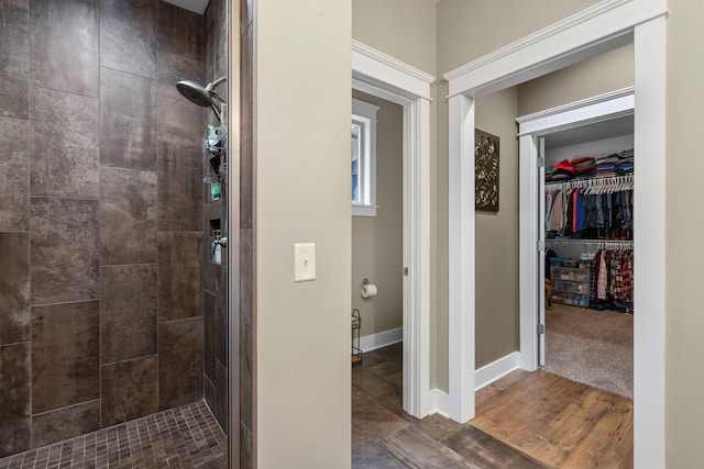 bathroom featuring wood-type flooring and tiled shower