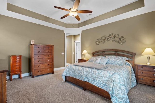 bedroom with ceiling fan, light colored carpet, and a raised ceiling