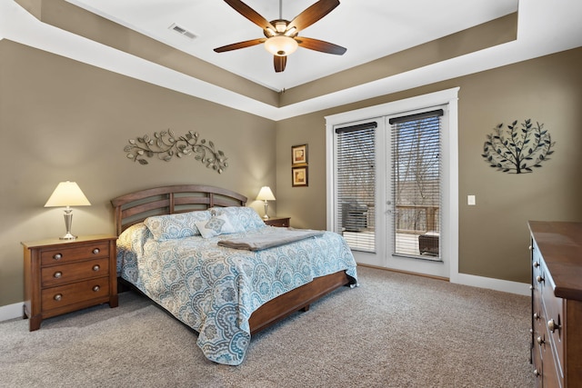 bedroom with ceiling fan, a tray ceiling, access to outside, and light carpet