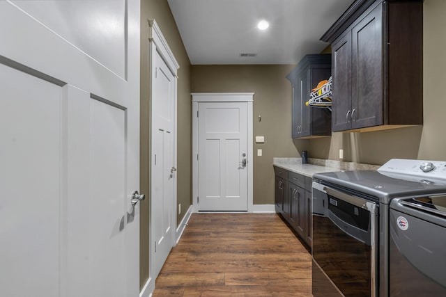 clothes washing area with dark hardwood / wood-style flooring, separate washer and dryer, and cabinets