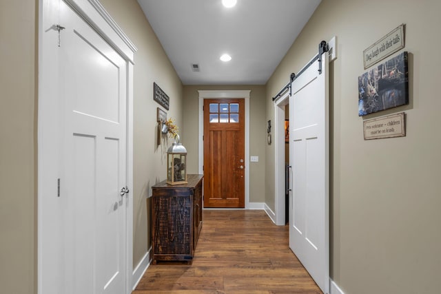 entryway with a barn door and dark hardwood / wood-style floors