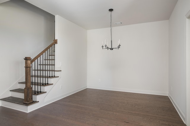 unfurnished dining area featuring a notable chandelier and dark hardwood / wood-style flooring