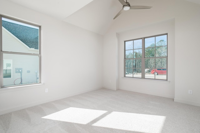 carpeted spare room featuring vaulted ceiling and ceiling fan