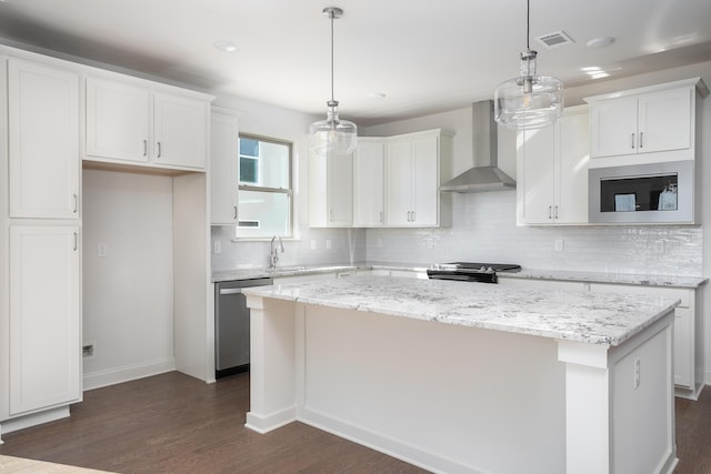 kitchen featuring hanging light fixtures, dishwasher, wall chimney exhaust hood, and a kitchen island