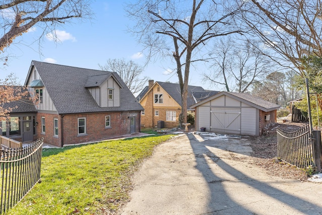 view of front of house with a front lawn and a storage shed