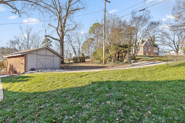 view of yard with a garage and an outbuilding