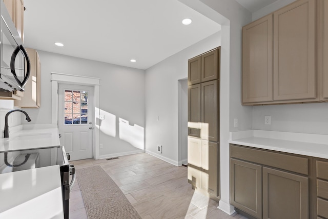 kitchen featuring range with electric stovetop and sink