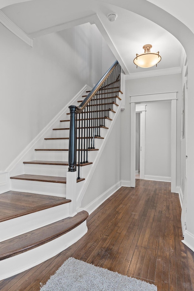 foyer entrance with dark hardwood / wood-style flooring and crown molding