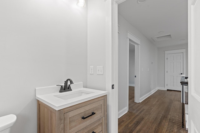 bathroom with toilet, hardwood / wood-style floors, and vanity