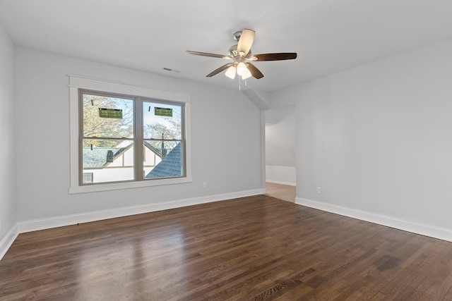 empty room with ceiling fan and dark hardwood / wood-style flooring