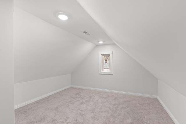 bonus room featuring lofted ceiling and light colored carpet