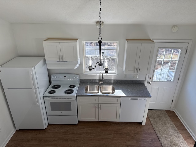 kitchen with white appliances, dark hardwood / wood-style flooring, hanging light fixtures, white cabinets, and sink