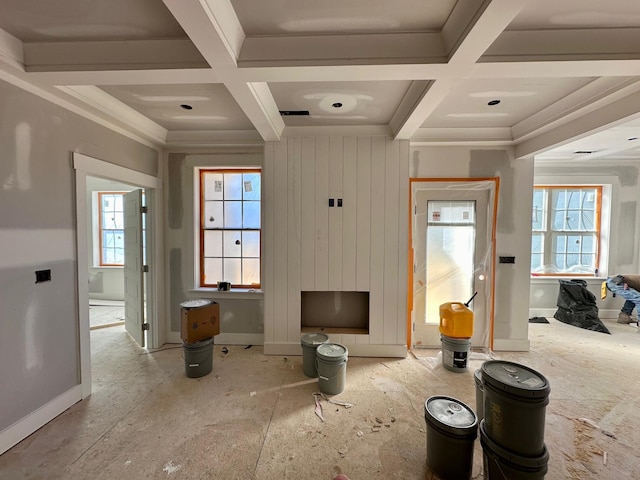 interior space featuring plenty of natural light, beam ceiling, coffered ceiling, and ornamental molding