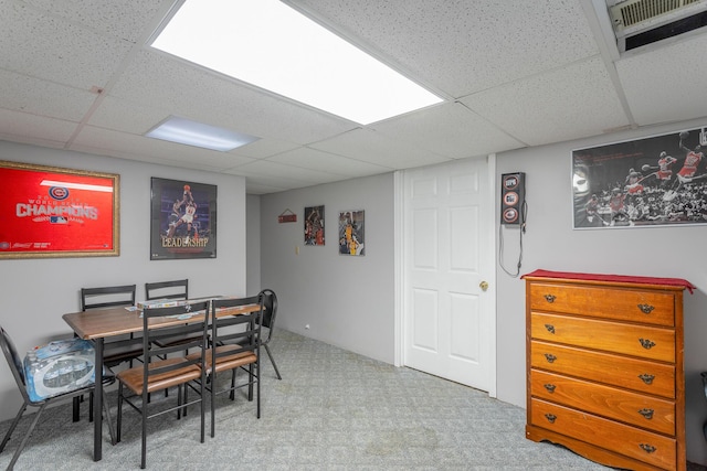 dining space with a paneled ceiling and light carpet