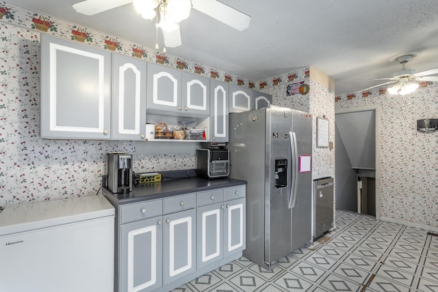 kitchen featuring white cabinets, stainless steel fridge, and ceiling fan