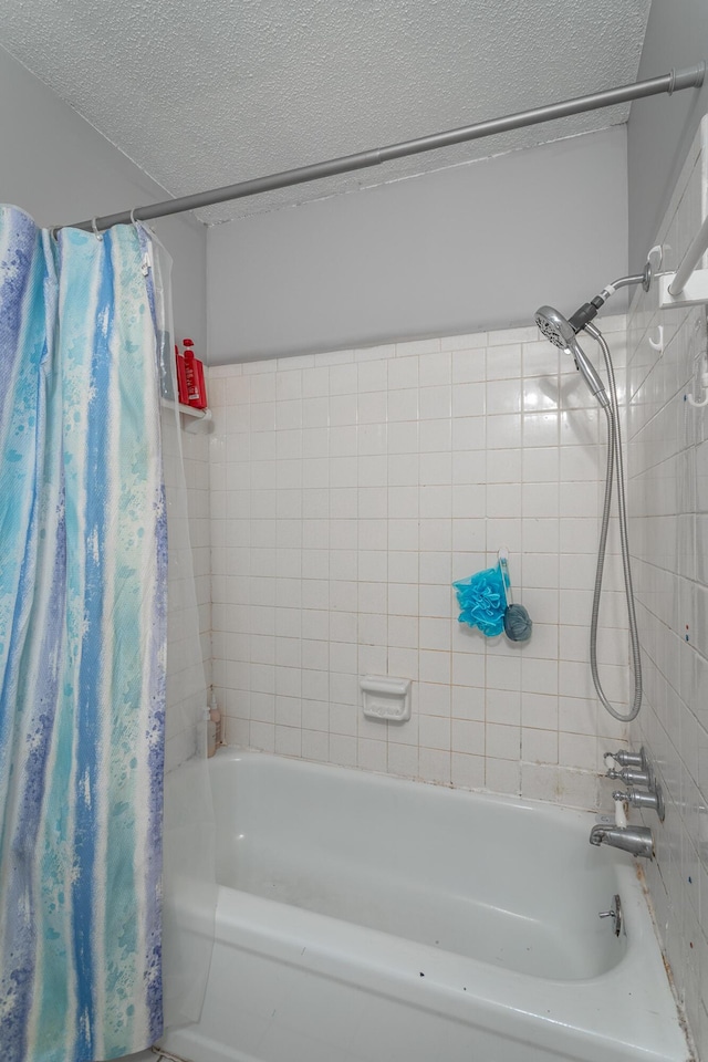 bathroom featuring shower / bathtub combination with curtain and a textured ceiling