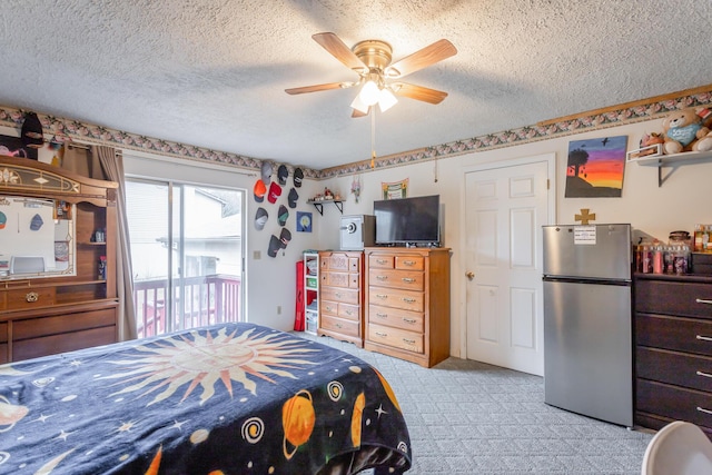 carpeted bedroom with access to outside, a textured ceiling, stainless steel fridge, and ceiling fan