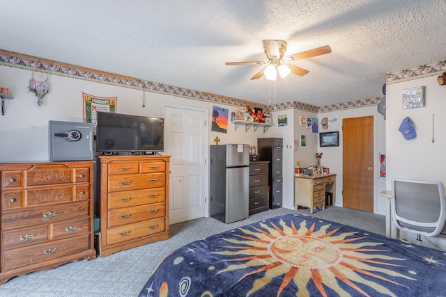 bedroom featuring stainless steel refrigerator, ceiling fan, light carpet, and a textured ceiling