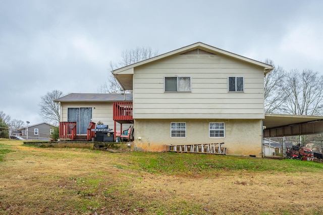 back of property featuring a lawn and a carport