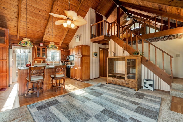 kitchen featuring appliances with stainless steel finishes, beamed ceiling, ceiling fan, high vaulted ceiling, and wooden ceiling