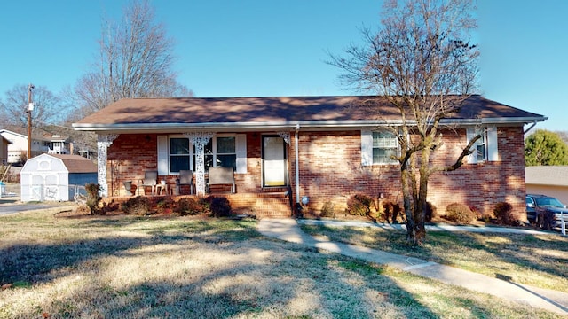 view of front facade featuring a storage shed, a front lawn, and a porch