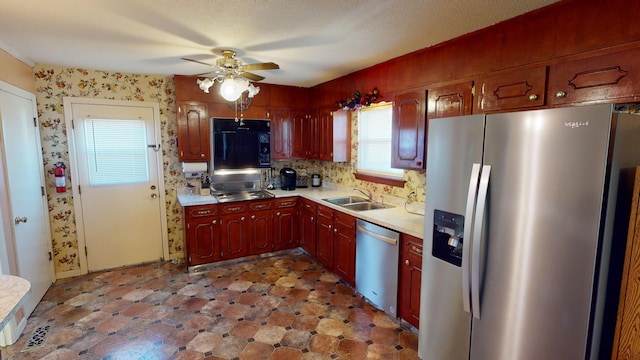 kitchen with ceiling fan, sink, stainless steel appliances, and a textured ceiling