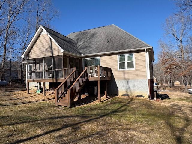 back of house with a deck, a sunroom, and a yard