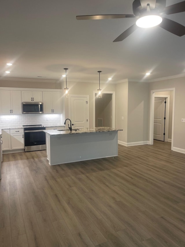 kitchen featuring an island with sink, appliances with stainless steel finishes, backsplash, pendant lighting, and white cabinets