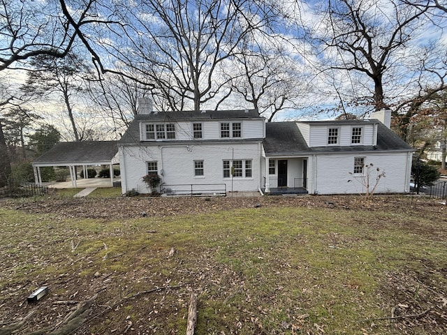 front of property with a front yard and a carport