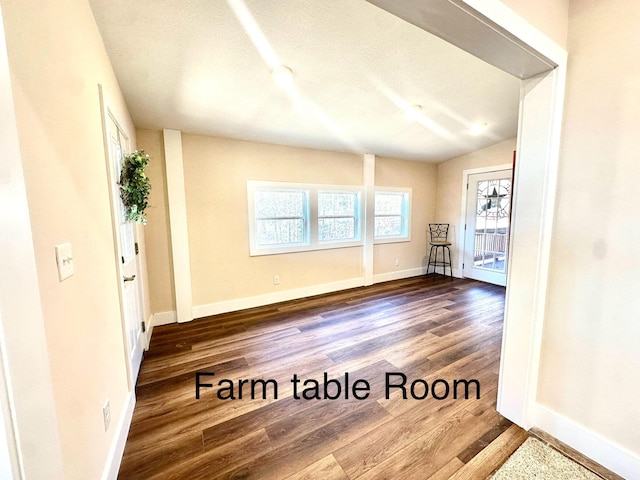 empty room featuring vaulted ceiling and hardwood / wood-style floors