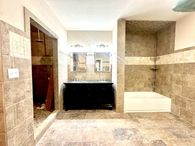 bathroom with tile walls, vanity, a textured ceiling, and shower with separate bathtub