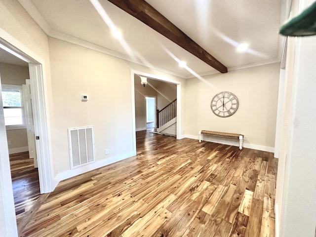 spare room with crown molding, beam ceiling, and hardwood / wood-style floors