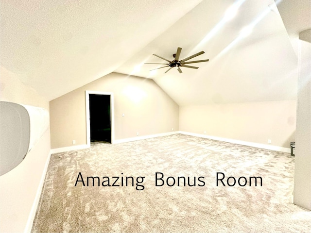 bonus room with vaulted ceiling, ceiling fan, carpet, and a textured ceiling