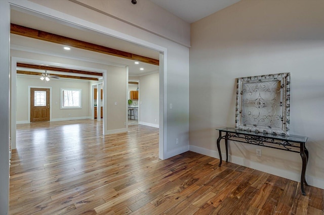 interior space with beamed ceiling, ceiling fan, and light wood-type flooring