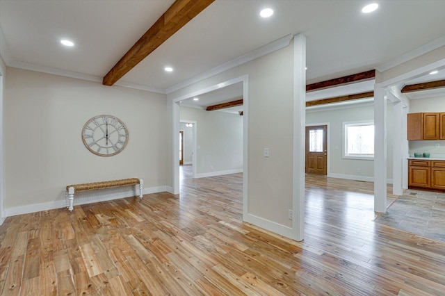 spare room with crown molding, beamed ceiling, and light wood-type flooring