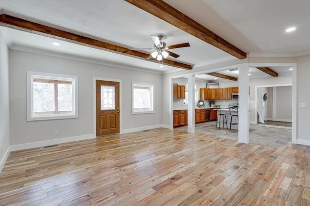 unfurnished living room with ceiling fan, crown molding, beamed ceiling, and light wood-type flooring