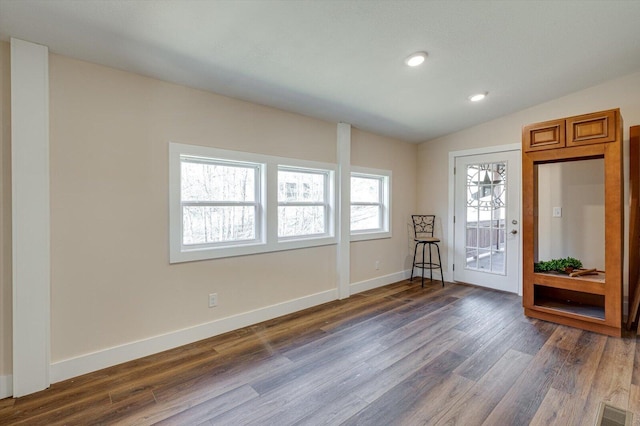 interior space with lofted ceiling and dark hardwood / wood-style flooring