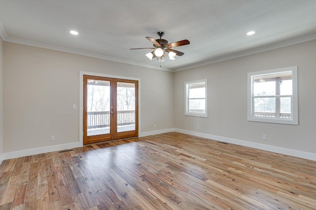 spare room with crown molding, a wealth of natural light, french doors, and light wood-type flooring