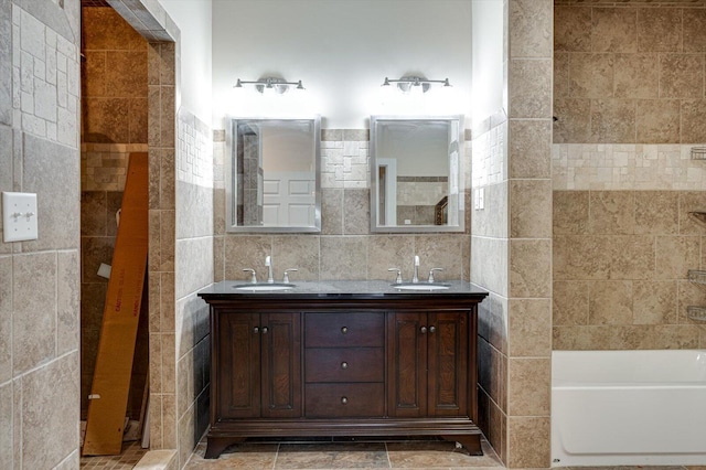 bathroom featuring tile walls, vanity, tasteful backsplash, and a tub