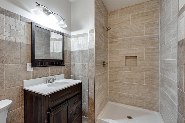 bathroom featuring vanity, toilet, and a tile shower