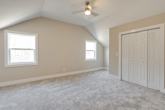 additional living space featuring lofted ceiling, light carpet, and ceiling fan