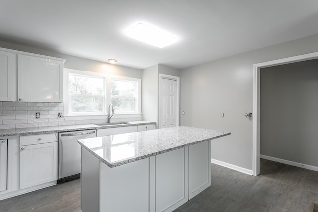 kitchen with white cabinetry, a kitchen island, sink, and stainless steel dishwasher