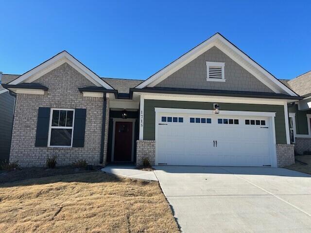 craftsman inspired home featuring a garage and a front lawn