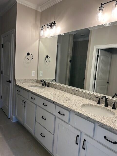 bathroom featuring a shower with shower door, vanity, tile patterned floors, and crown molding