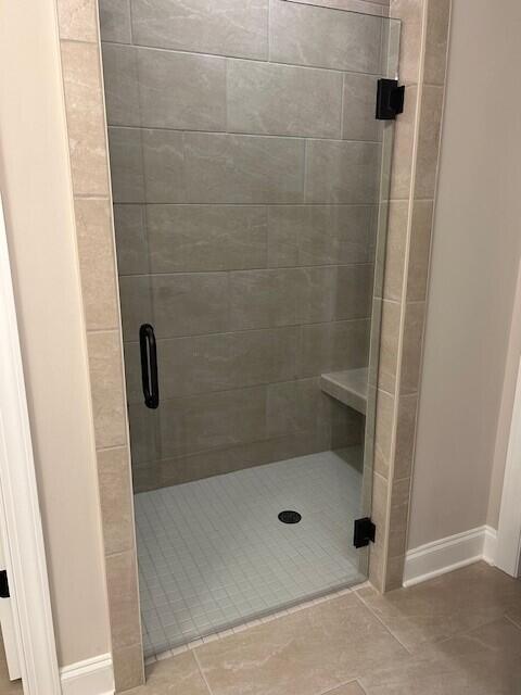 bathroom with tile patterned flooring and a shower with door