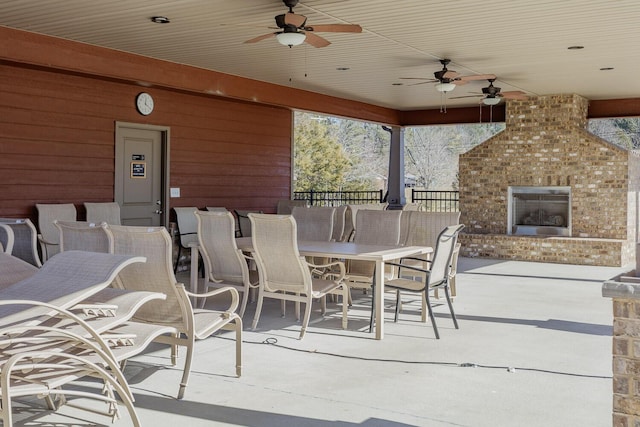 view of patio with an outdoor brick fireplace and ceiling fan