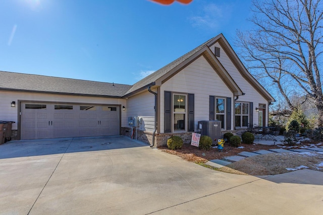 view of front of property with a garage and central air condition unit