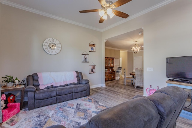 living room with ceiling fan with notable chandelier, crown molding, and light hardwood / wood-style floors