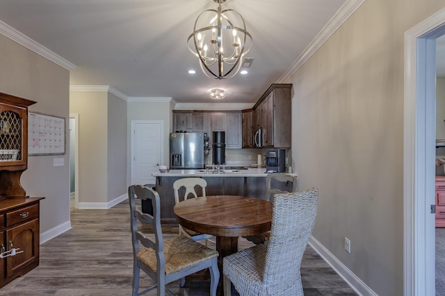 dining area featuring an inviting chandelier, ornamental molding, and wood-type flooring