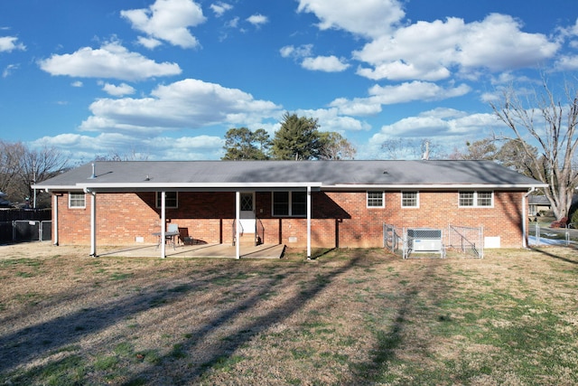 rear view of house with a lawn and a patio